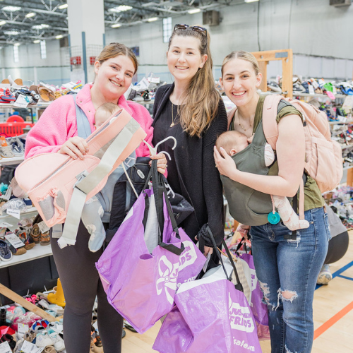 A mother and daughter stand side by side in their masks as they shop their local JBF sale.